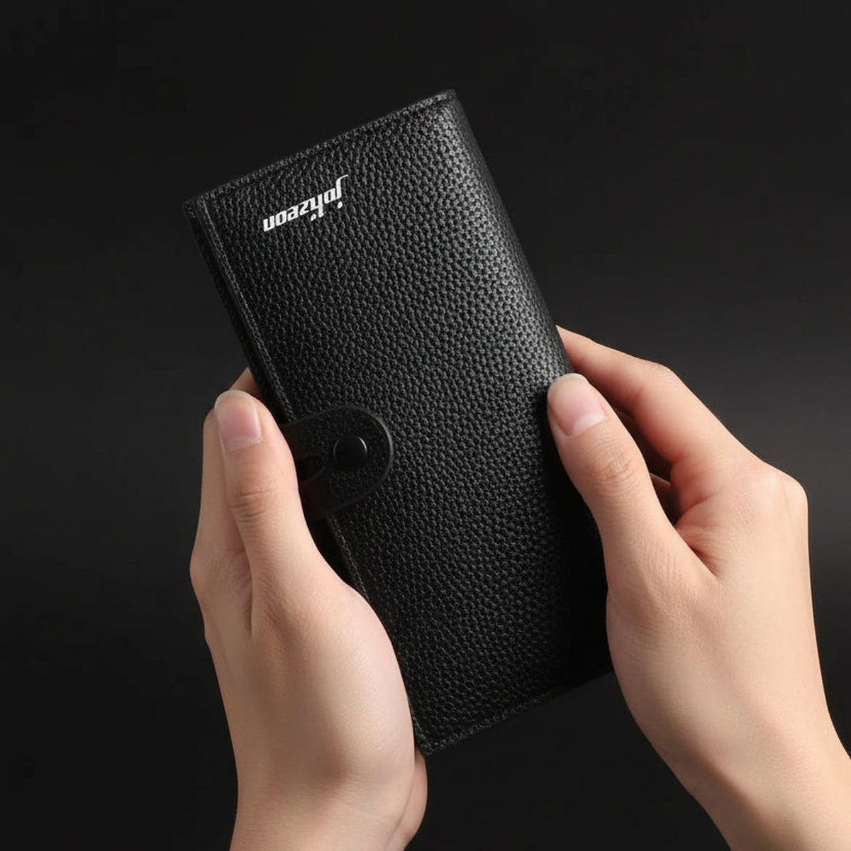 Snap Wallet in Schwarz wird in der Hand gehalten, Druckknopf geschlossen