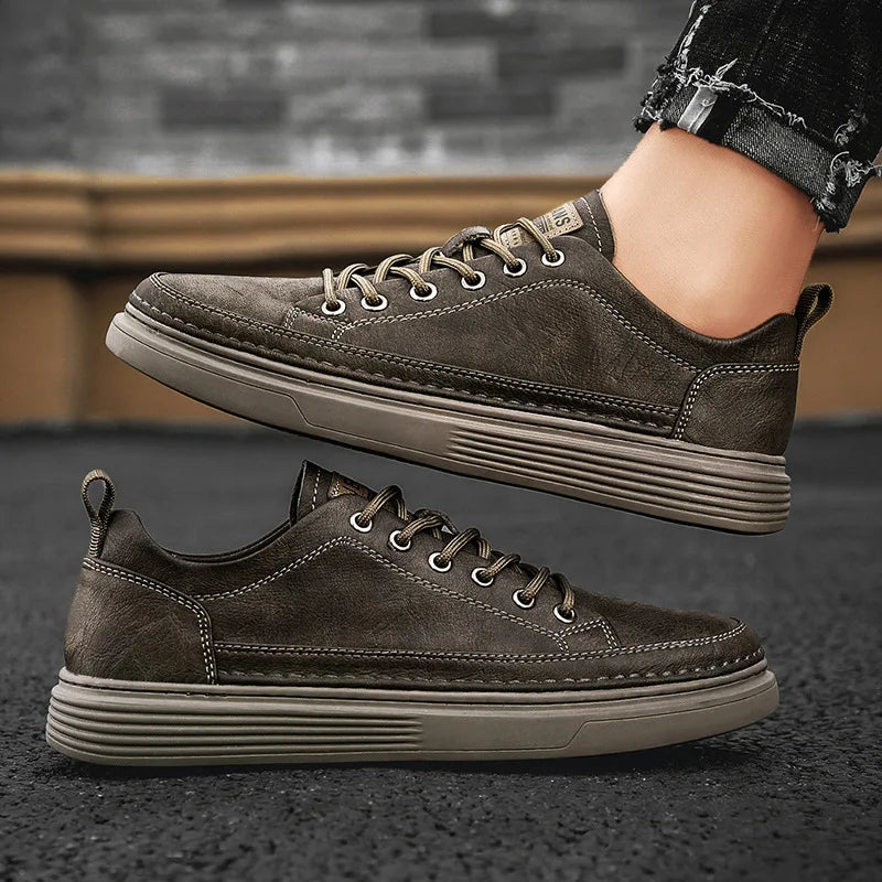 Herren-Sneaker in Graubraun am Fuß getragen, daneben ein Einzelschuh